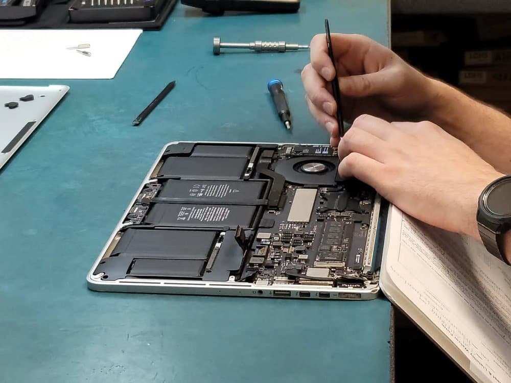 Technician working inside an opened MacBook Pro